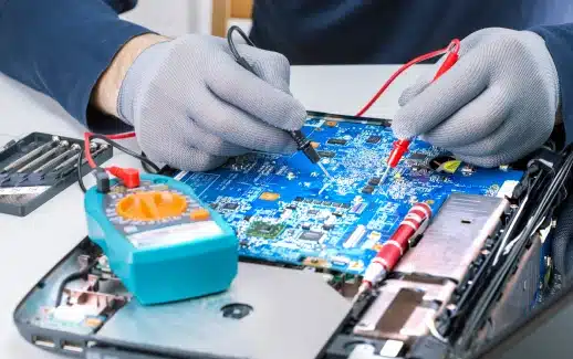 Technician repairing circuit board with multimeter